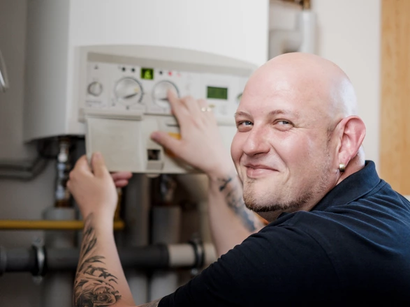 Ein Hausmeister stellt die Heizung im Heizungsraum einer CJD Einrichtung ein.